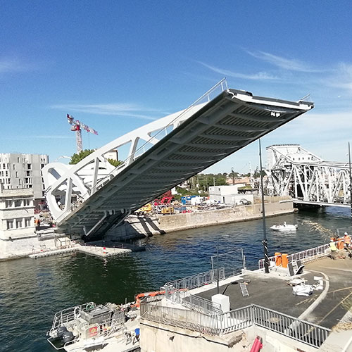 Installation de vérins hydrauliques sous le pont mobile basculant roulant de Sète (34), permettant chacun de mouvoir environ 200 tonnes.  Construction et mise en œuvre d’une centrale hydraulique pour la manœuvre du pont.