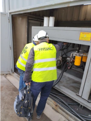 Techniciens EDHD et HYDAC réalisant une analyse d'huile hydraulique sur une installation industrielle directement sur site.
